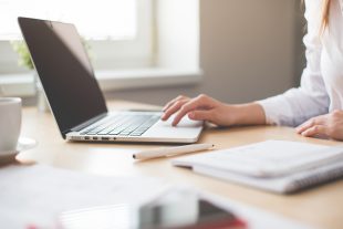 Picture of women sat at table working on a laptop