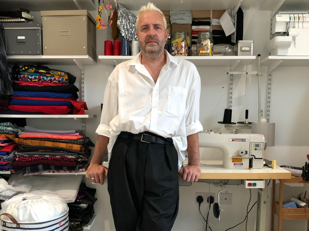 Man leaning on sewing desk